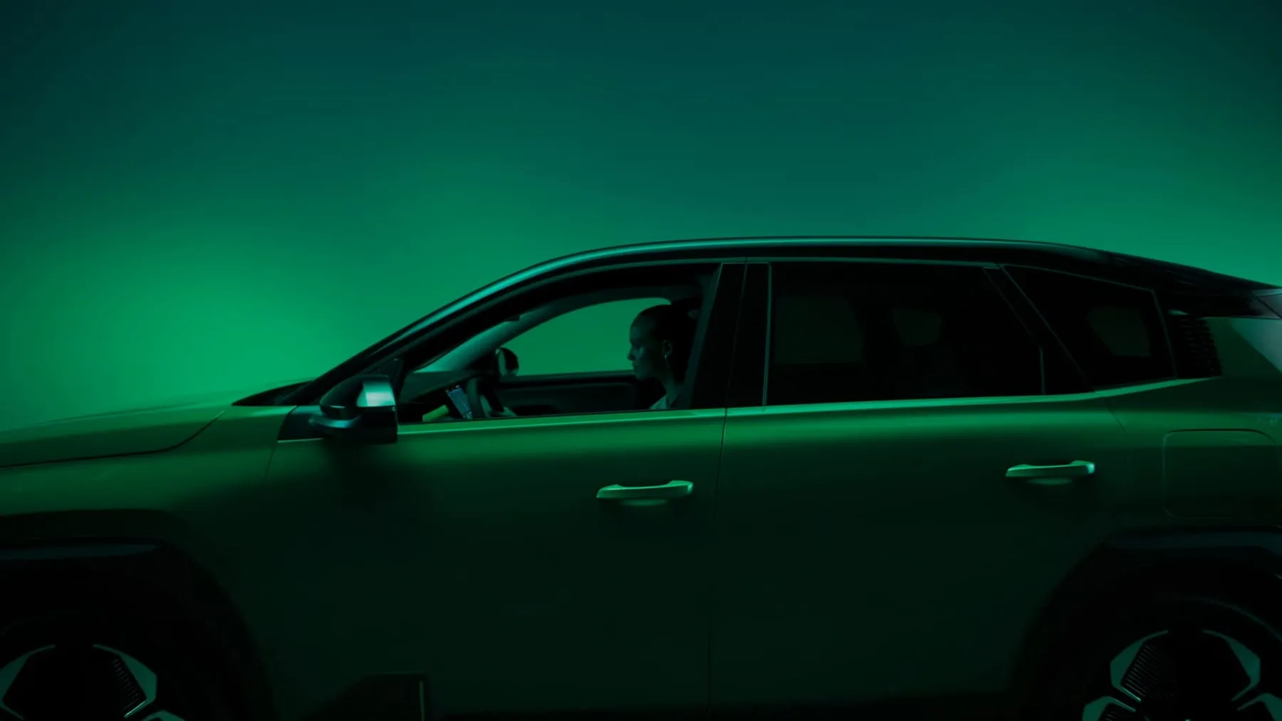 The car in profile against a green field of light
