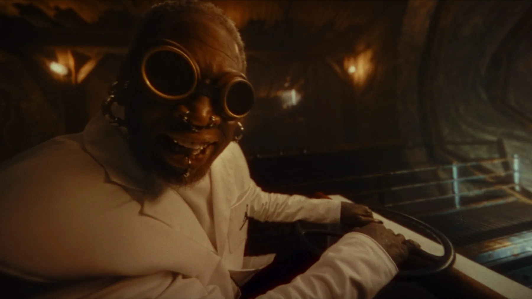 Dennis Rodman in white, goggles on, at the controls