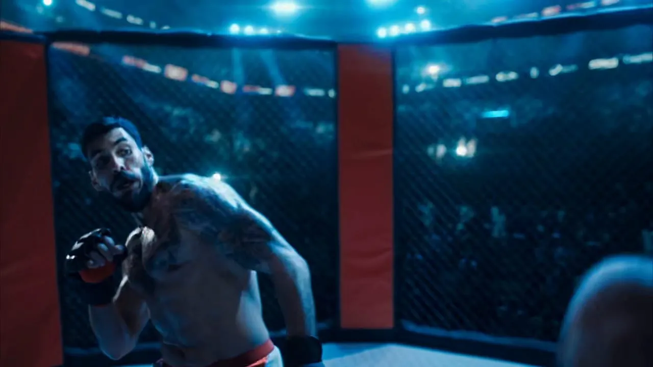 An MMA fighter at the cage under arena light