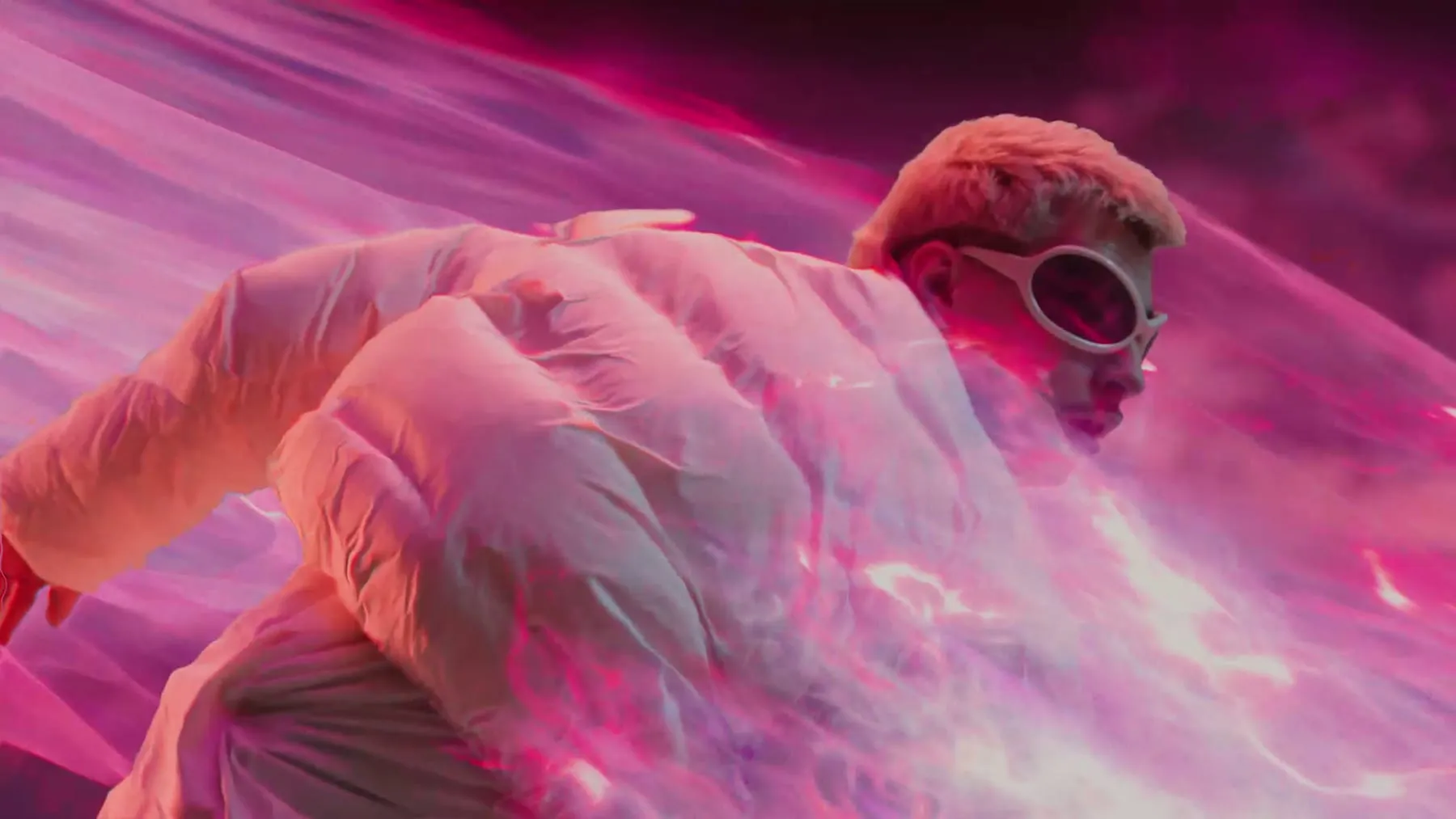 Close on a puffer jacket and goggles in pink light