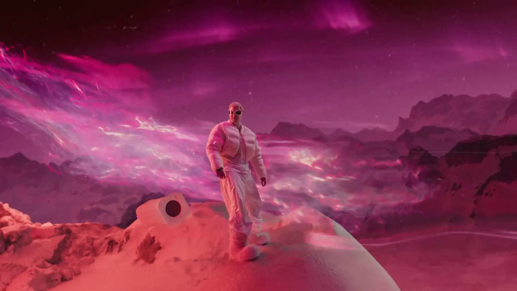 The magenta world in wide shot, one figure walking it