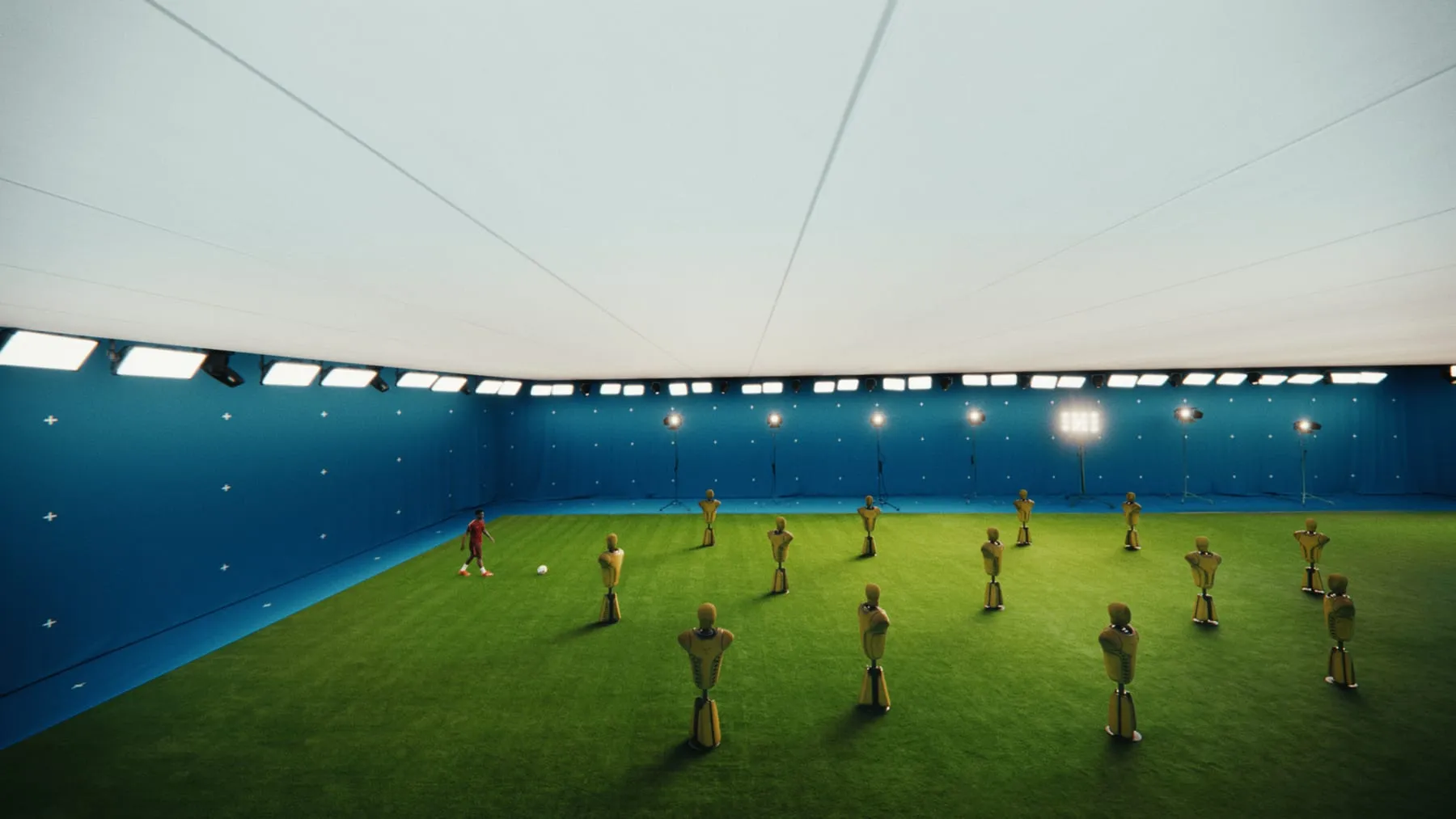 The blue arena in wide shot, ranks of yellow CG training dummies standing on the pitch