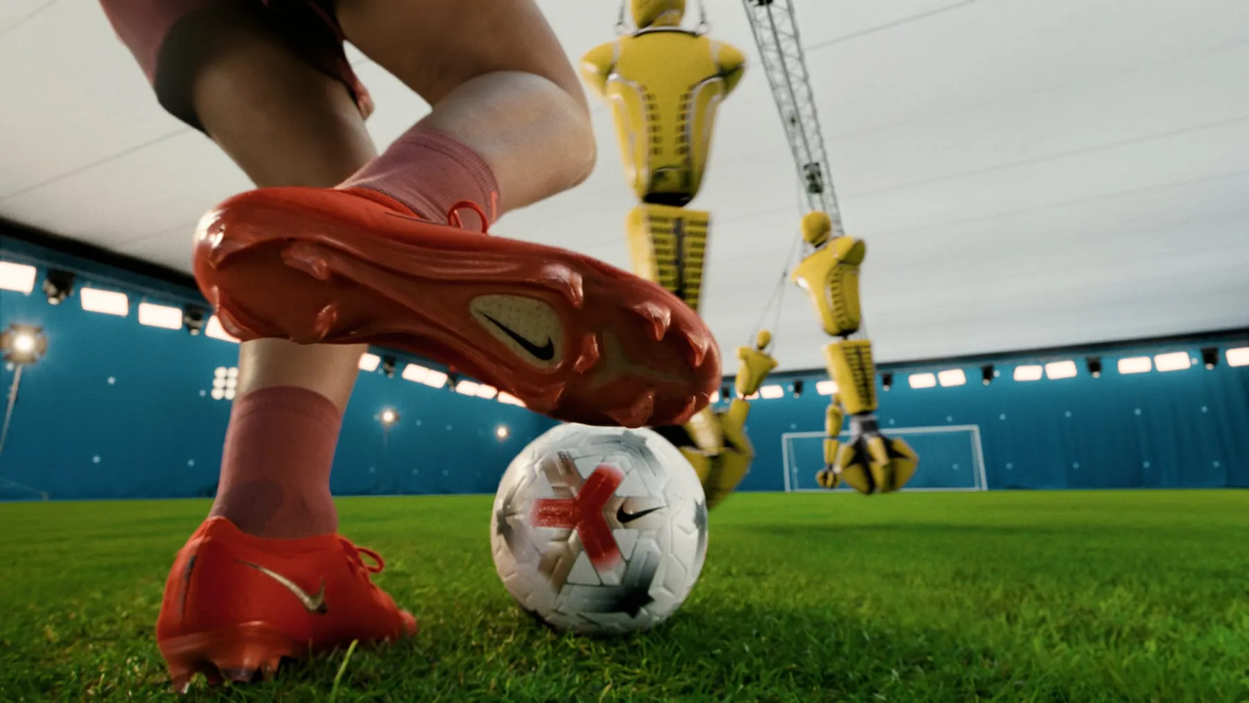 Low angle on a red Mercurial boot about to strike the ball