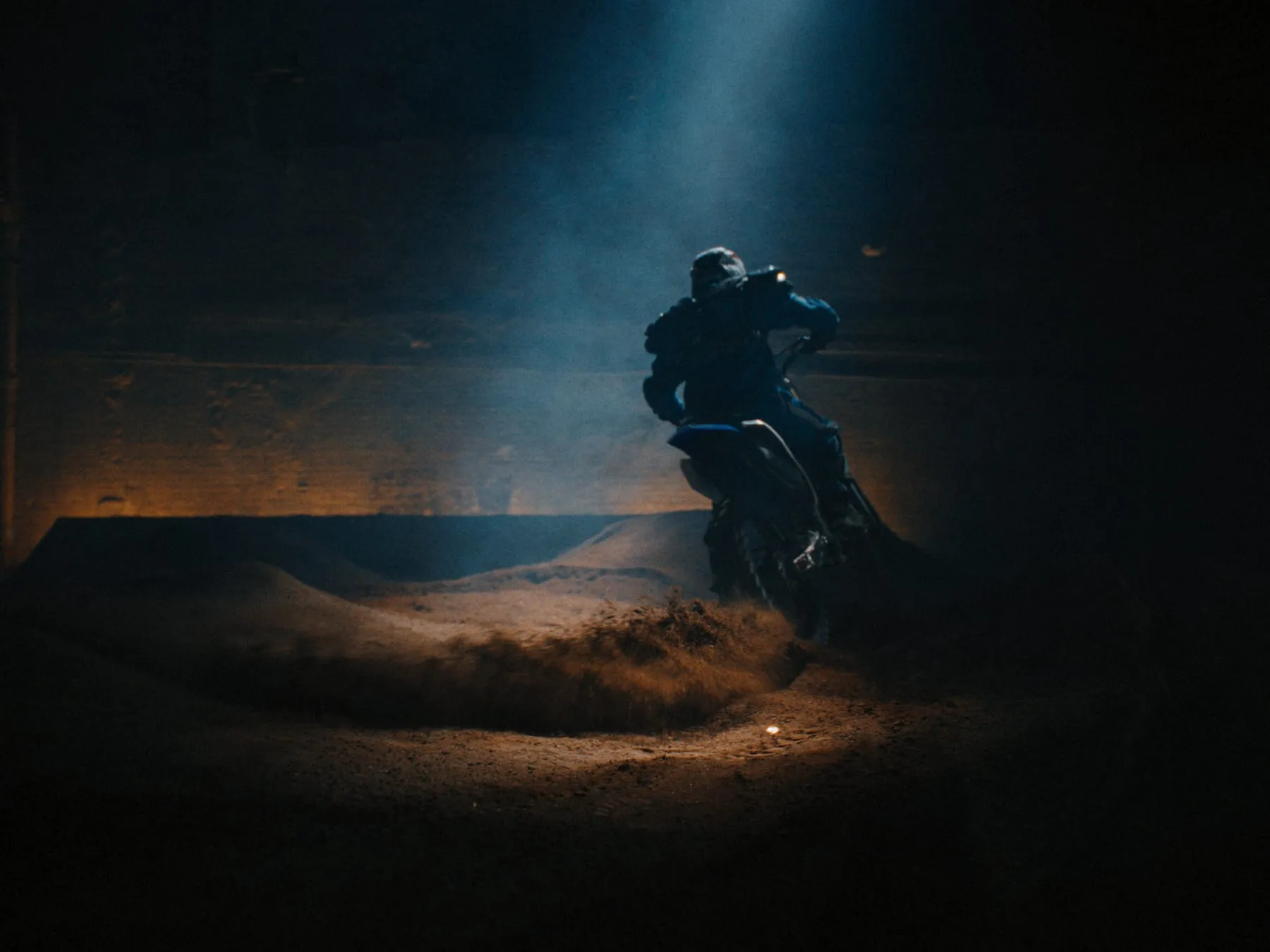 A rider silhouetted on a dune at dusk