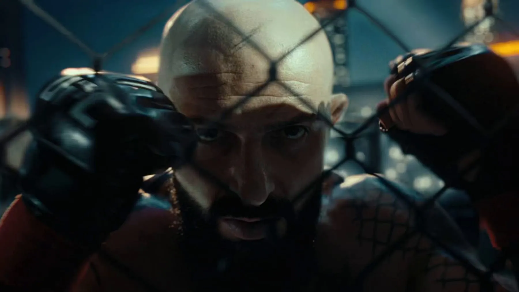 A fighter pressed against the cage, gloves up, arena lights behind
