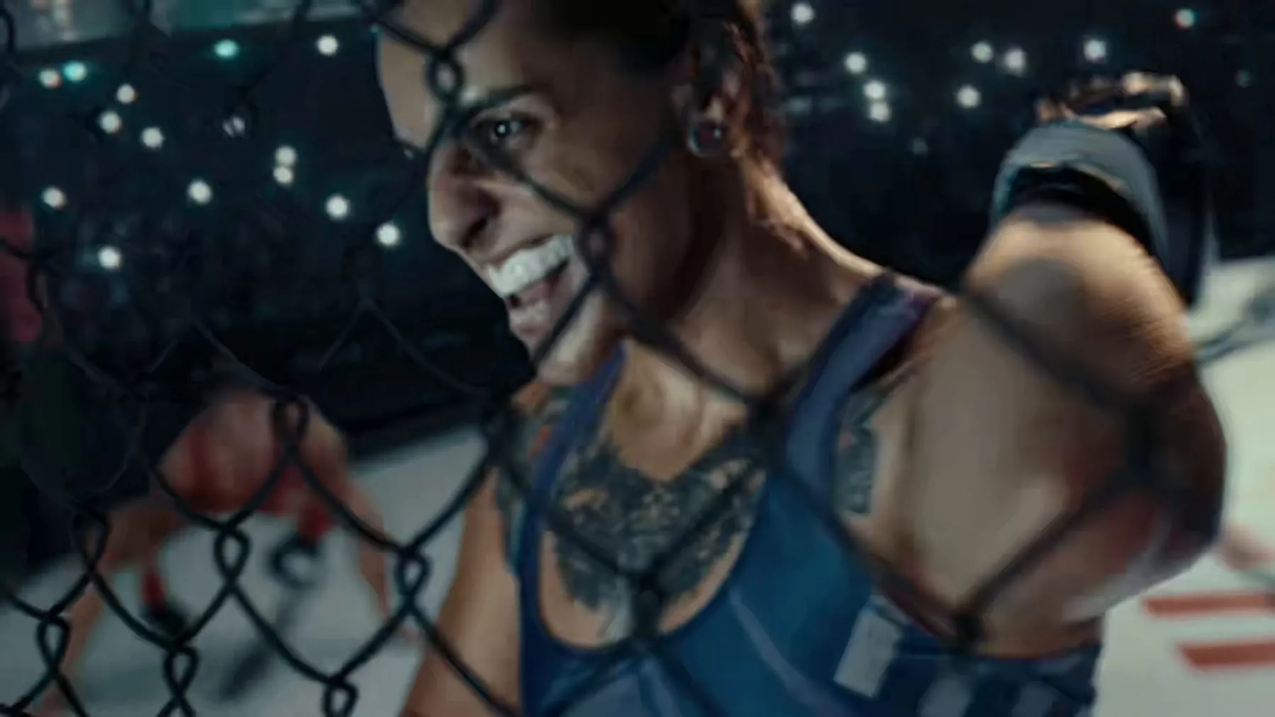 A fighter mid-shout behind the chain-link of the octagon